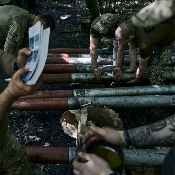 Ukrainian soldiers prepare shells with flyers urging the Russian soldiers to surrender to fire toward the Russian positions near Bakhmut, Donetsk region, Ukraine, Sunday, Aug. 13, 2023. (AP Photo/Libkos)