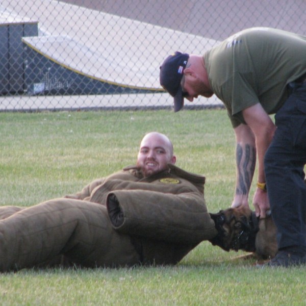 File - Michigan City Police Department Officer Mike Petrie tries to convince his K-9 partner Edo to let go of a "suspect" he chased down during a demonstration at the National Night Out event on Tuesday, Aug. 1, in Pullman Park in Michigan City.