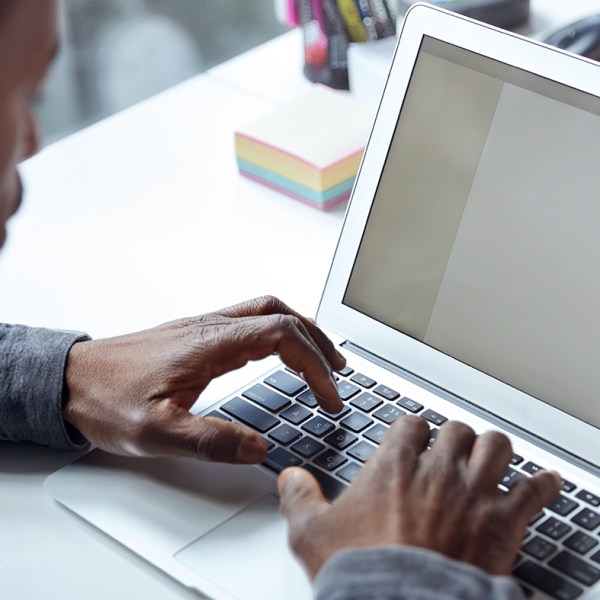 Person types on a small laptop at a conference table